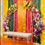 A colorful floral arch and elegant bench setup, ideal for professional Event decoration services in Lahore.