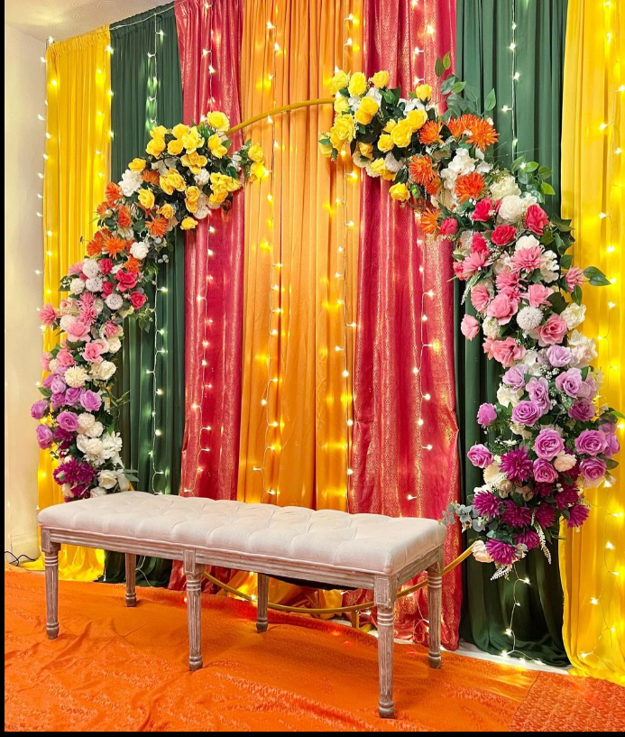 Festive Mehndi Backdrop A colorful floral arch and elegant bench setup, ideal for professional Event decoration services in Lahore.