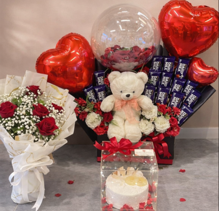 Luxury chocolate bouquet Lahore featuring 15 chocolate bars, imported red flowers, and a pineapple cake.