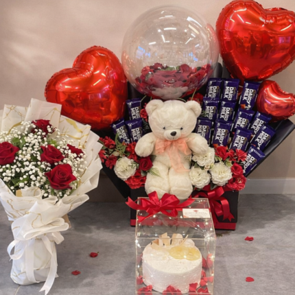 Luxury chocolate bouquet Lahore featuring 15 chocolate bars, imported red flowers, and a pineapple cake.