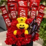 Chocolate Gift Basket Lahore with KitKat, Snickers, teddy bears, and red flowers.