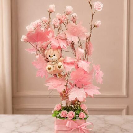 Flower tree Lahore with pink roses, teddy bear, and decorative leaves.