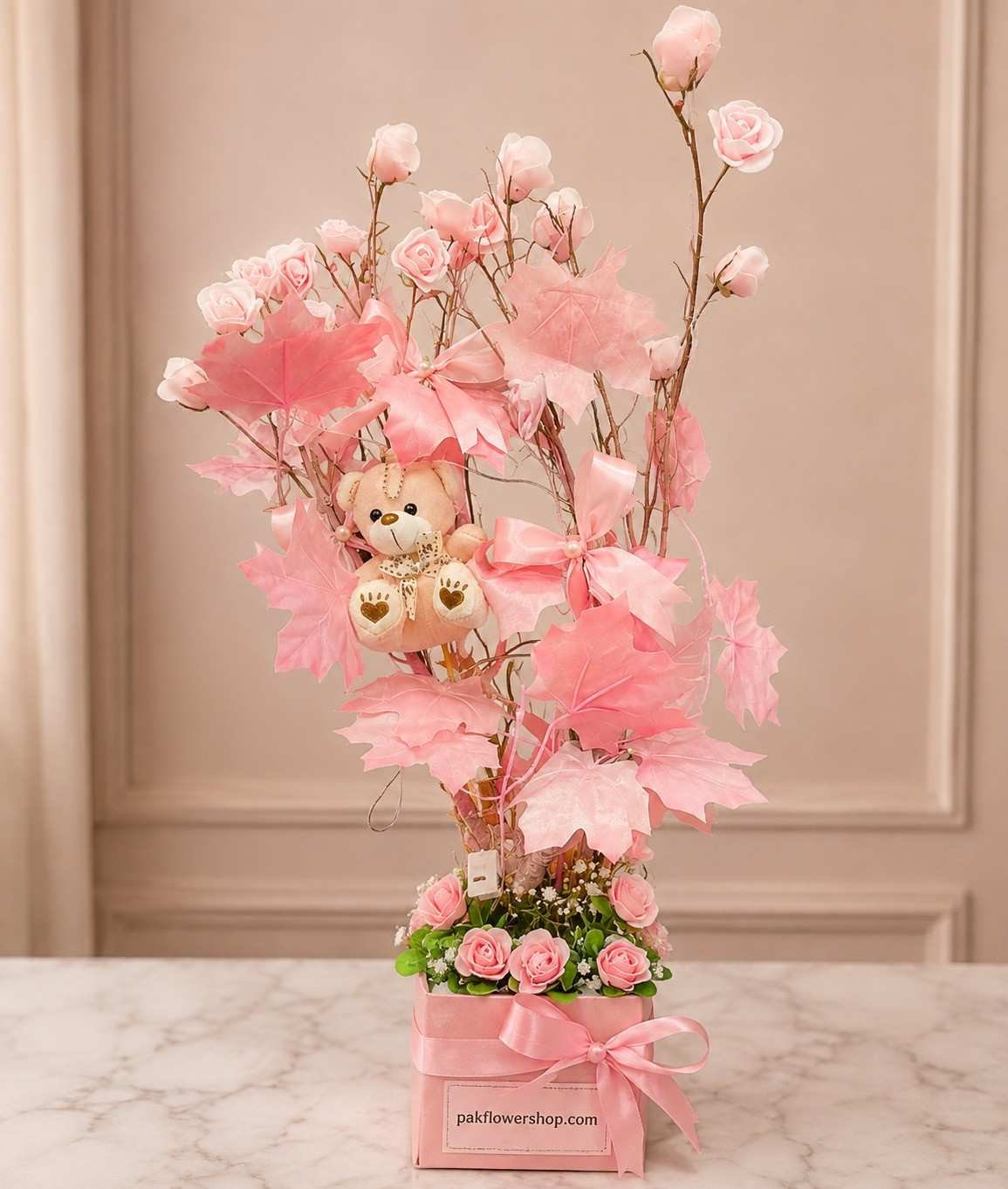Pink Rose Tree Flower tree Lahore with pink roses, teddy bear, and decorative leaves.