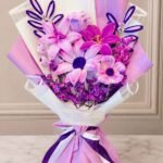 Lahore flower bouquet with purple and pink fresh flowers in elegant gift wrapping.
