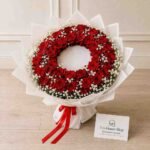 Fresh Funeral Flower Wreath made with red roses and white baby's breath
