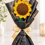 Crochet flower gift Lahore featuring handmade yellow sunflower and black gold wrapping