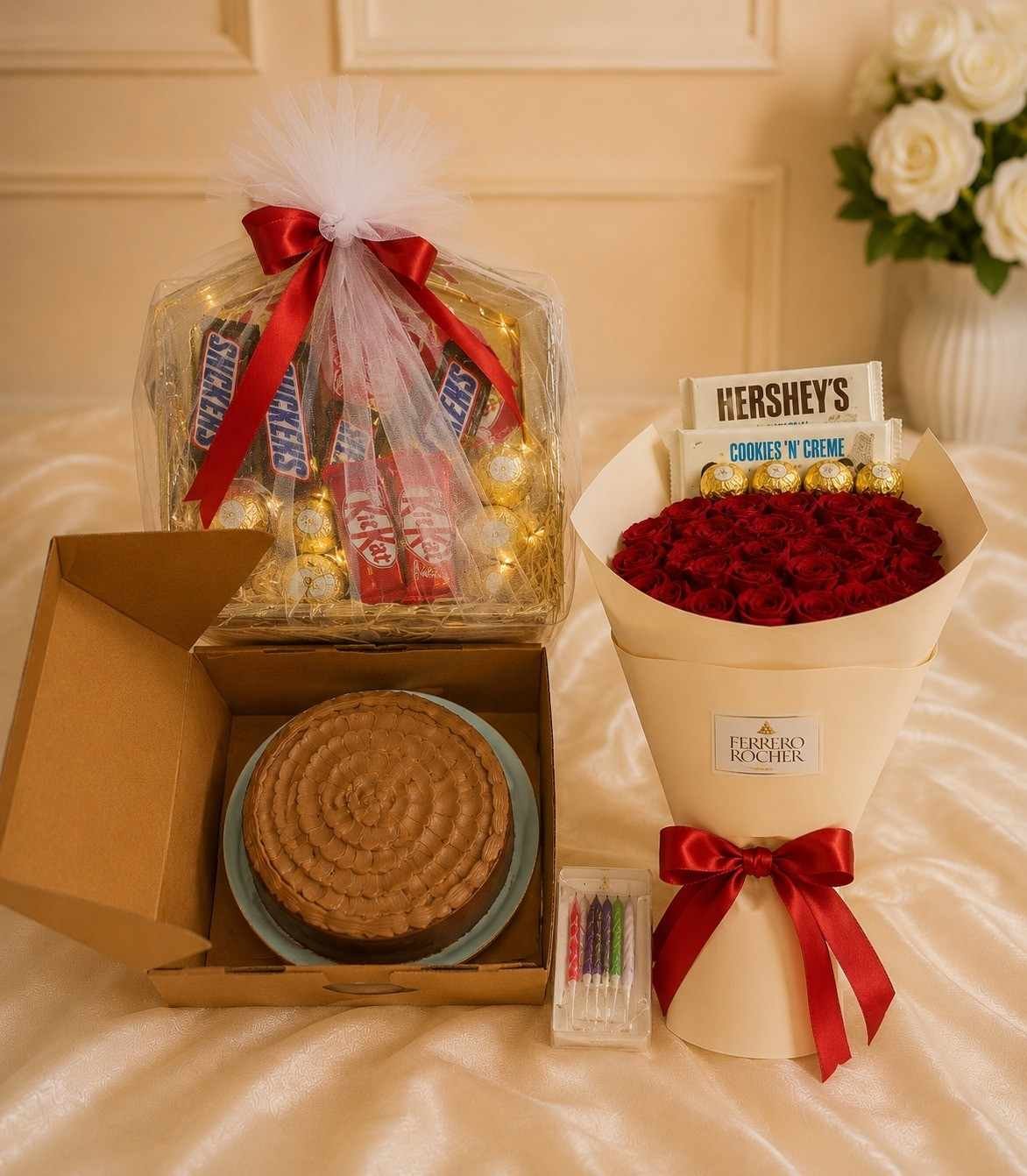 Ultimate Gift Combo to Send Flowers and Cakes Fresh red rose bouquet next to a chocolate cake and gift box for people who send flowers and cakes
