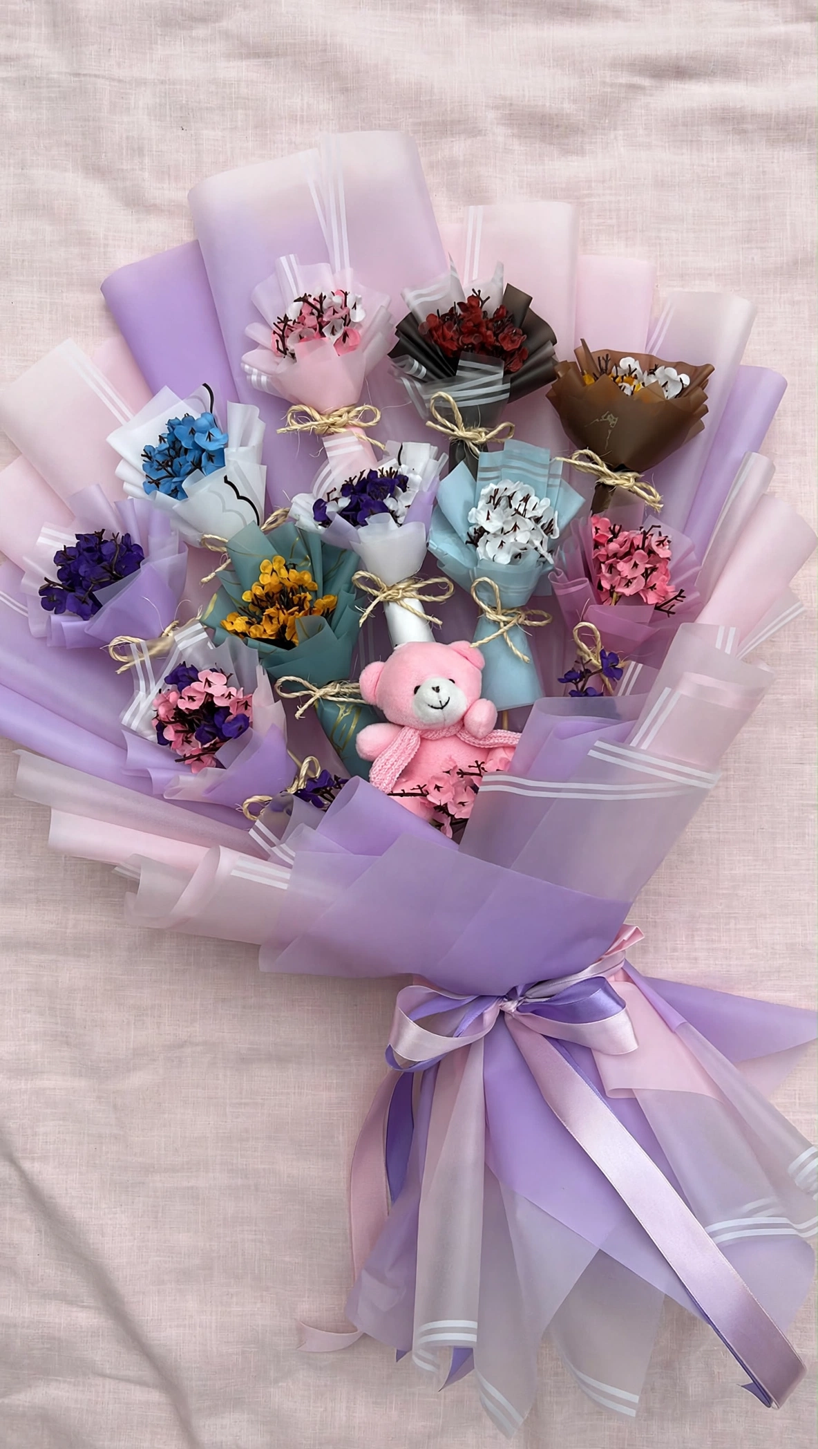Mini handmade bouquets bunch flat lay on pink linen