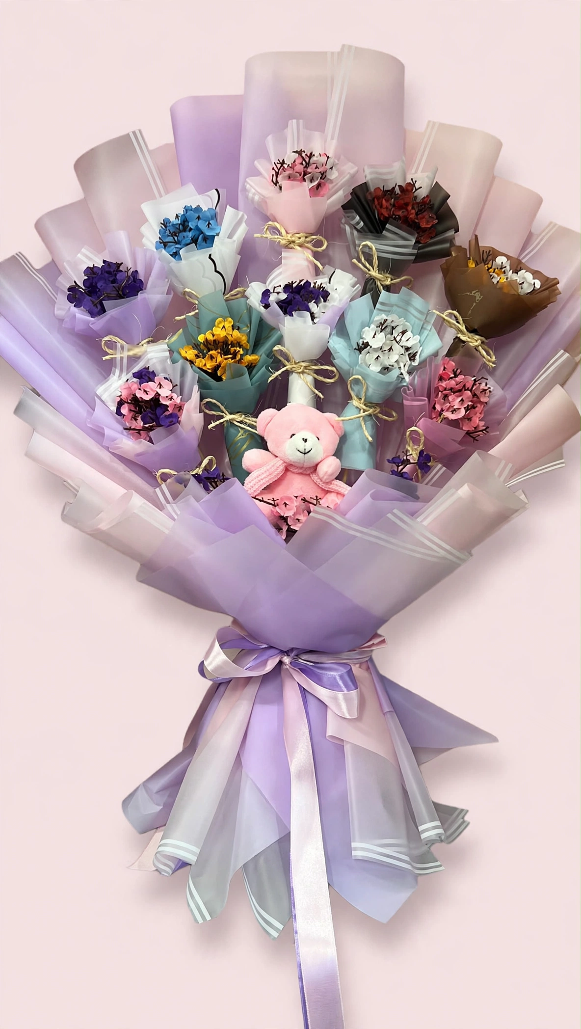 Bunch of mini handmade bouquets with pink teddy in lavender wrapping