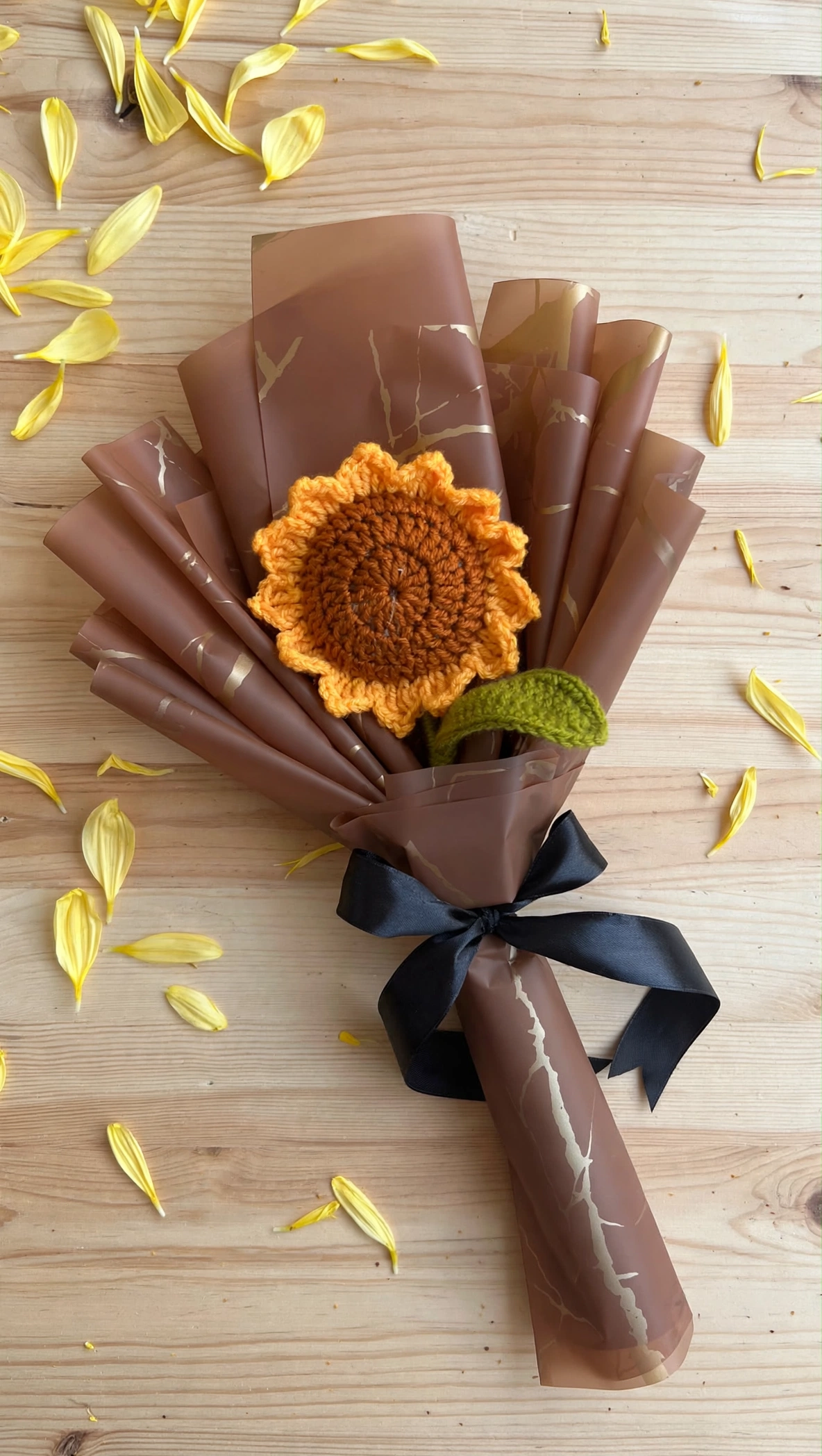 Handmade crochet sunflower bouquet flat lay on a wooden table with yellow petals